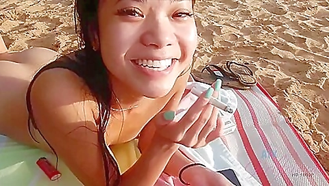 Blonde girl gets on top of a dude on the beach outdoors