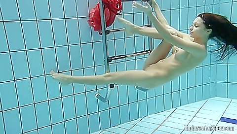 Horny brunette in a bikini is in the pool and in a shower