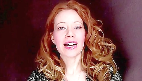 Redheaded girl masturbates on the bed after stripping